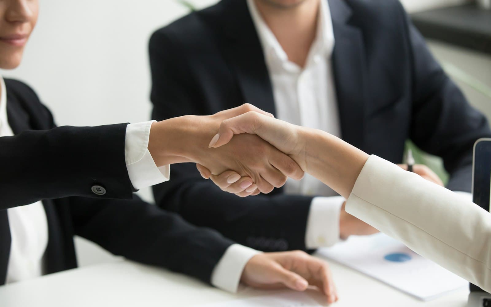 Two people working through a property settlement discussion with a mediator at a table.