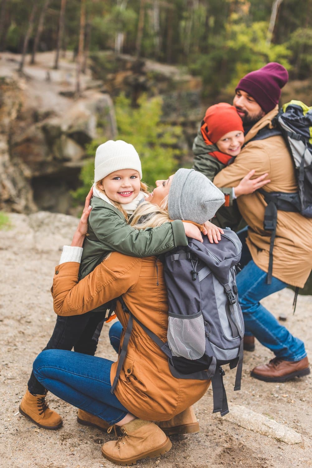 A family hugging their children outdoors
